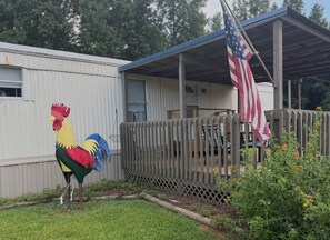 Ein Wohngebiet mit einer großen Dekoration in Form eines Hahns, einem Holzzaun und einer US-amerikanischen Flagge.