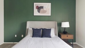 A bedroom with a bed, a nightstand, a lamp, and a wall-mounted abstract artwork. - Landing | Stylish 1BD, Gym, Clubhouse (Houston)
