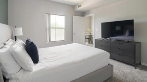 A modern bedroom with a large bed, a television, and a dresser. - Landing | Modern 1BD, Gym, Clubhouse (Houston)