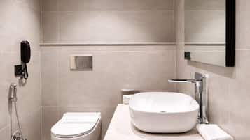 Un baño moderno con inodoro, lavabo y ducha.