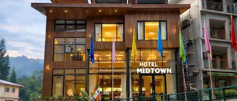 A hotel with a modern design, featuring a prominent entrance and multiple flags.