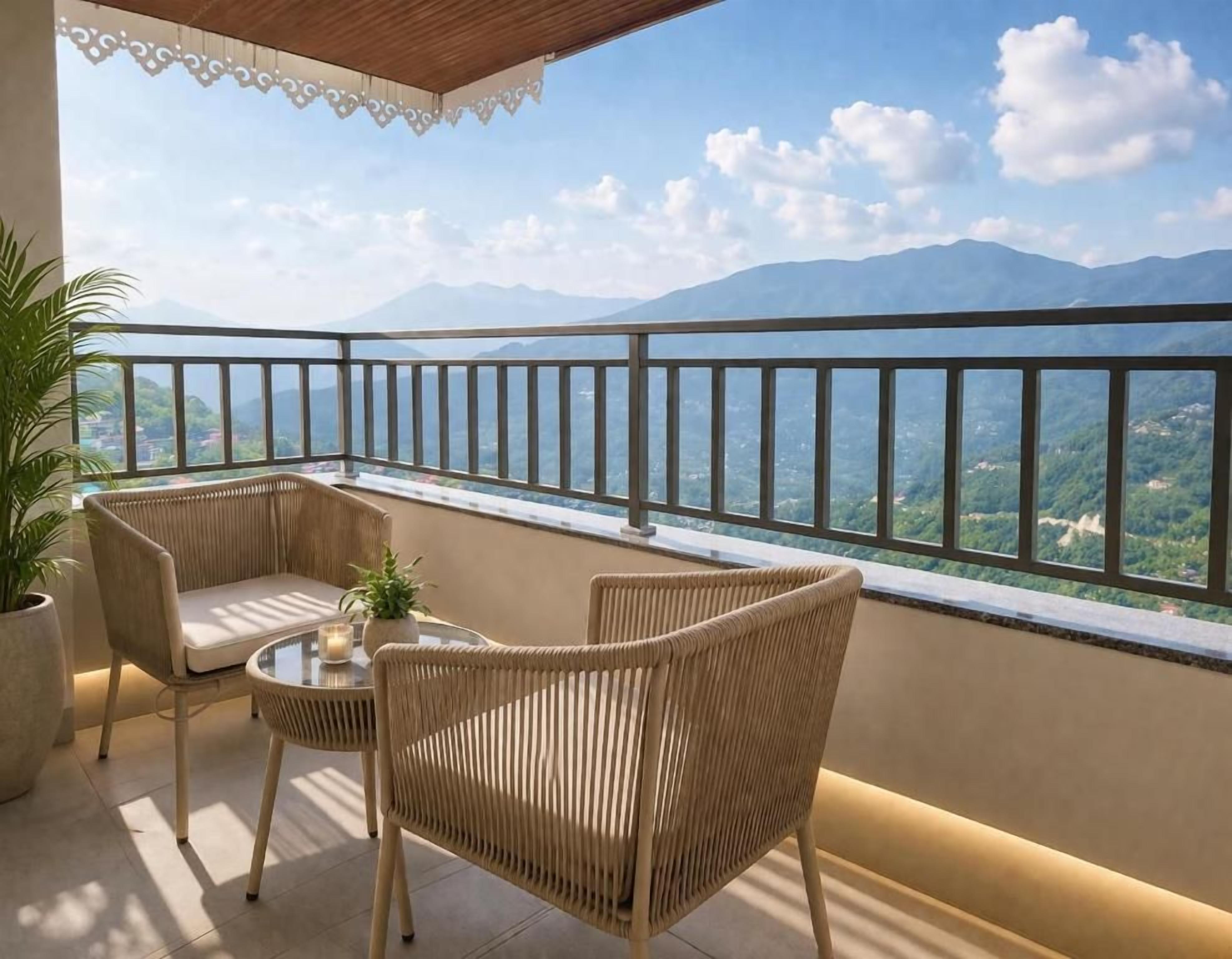 A balcony with wicker furniture, a table with a candle, and a view of mountains.