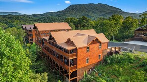 A wooden cabin with multiple levels, a deck, and a view of a mountain. - Luxury BRAND NEW 8bdrm Cabin-Pool-Arcades-Gazebo (Sevierville)