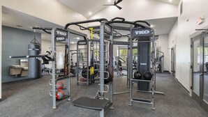 Ein Fitnessstudio mit Geräten der Marke TKO, darunter ein Kniebeugenständer, eine Langhantelbank und verschiedene Kraftgeräte.