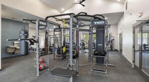A gym with TKO branded equipment, including a squat rack, bench press, and various weight machines. - Landing | Stunning 1BD, Gym, Clubhouse (Houston)