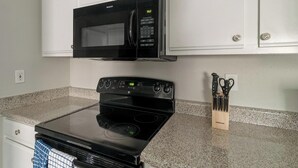 A kitchen with a black microwave, stove, and granite countertop. - Landing | Amazing 2BD, Gym, Clubhouse (Houston)