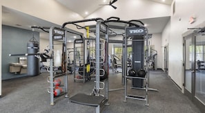 Ein Fitnessstudio mit Geräten der Marke TKO, darunter ein Kniebeugenständer, eine Langhantelbank und verschiedene Kraftgeräte.