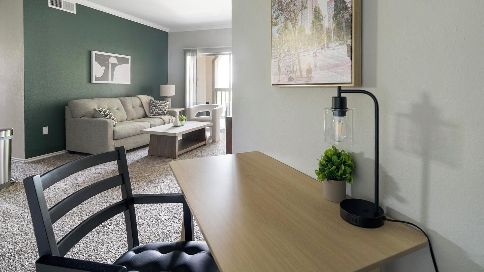 A modern living room with a sofa, coffee table, and a dining area with a chair and table.