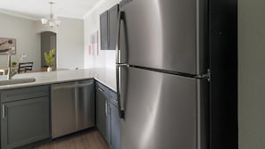 A modern kitchen with stainless steel appliances, a dishwasher, and a two-door refrigerator. - Landing | Incredible 3BD, Gym, Clubhouse (Houston)