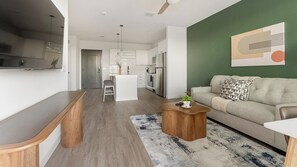Ein zeitgemäßer Wohnraum mit Küche, Essbereich und einer Couch.