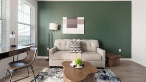 A modern living room with a sofa, coffee table, and a lamp. - Landing | Spectacular 1BD, Yoga Studio, Game Room (Punta Gorda)