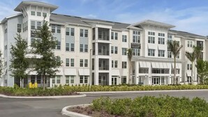 A multi-story hotel with a modern architectural design, featuring a central entrance and multiple windows. - Landing | Spectacular 1BD, Yoga Studio, Game Room (Punta Gorda)