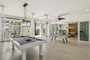 Ein moderner Pooltisch in Innenräumen mit Essbereich und Blick ins Freie.