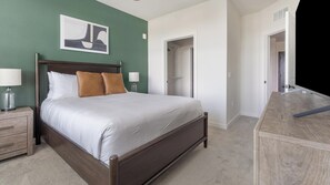 Ein Schlafzimmer mit einem Bett, Nachttischen, einem Spiegel und einem Kleiderschrank.