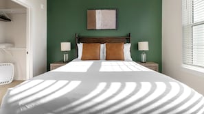 A neatly made bed with a white duvet, two bedside lamps, and a headboard. - Landing | Spectacular 2BD, Gym, Game Room (Punta Gorda)