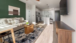 Un salon moderne avec un canapé, une table basse et une vue sur la cuisine.