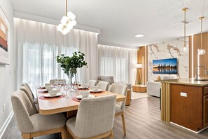 A modern hotel room with a dining area, a kitchen, and a living space. - Mickey & Mario Luxury Retreat, Private Pool (Kissimmee)