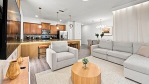 Ein modernes Wohnzimmer mit einer Couch, einem Couchtisch und einer Küche im Hintergrund.