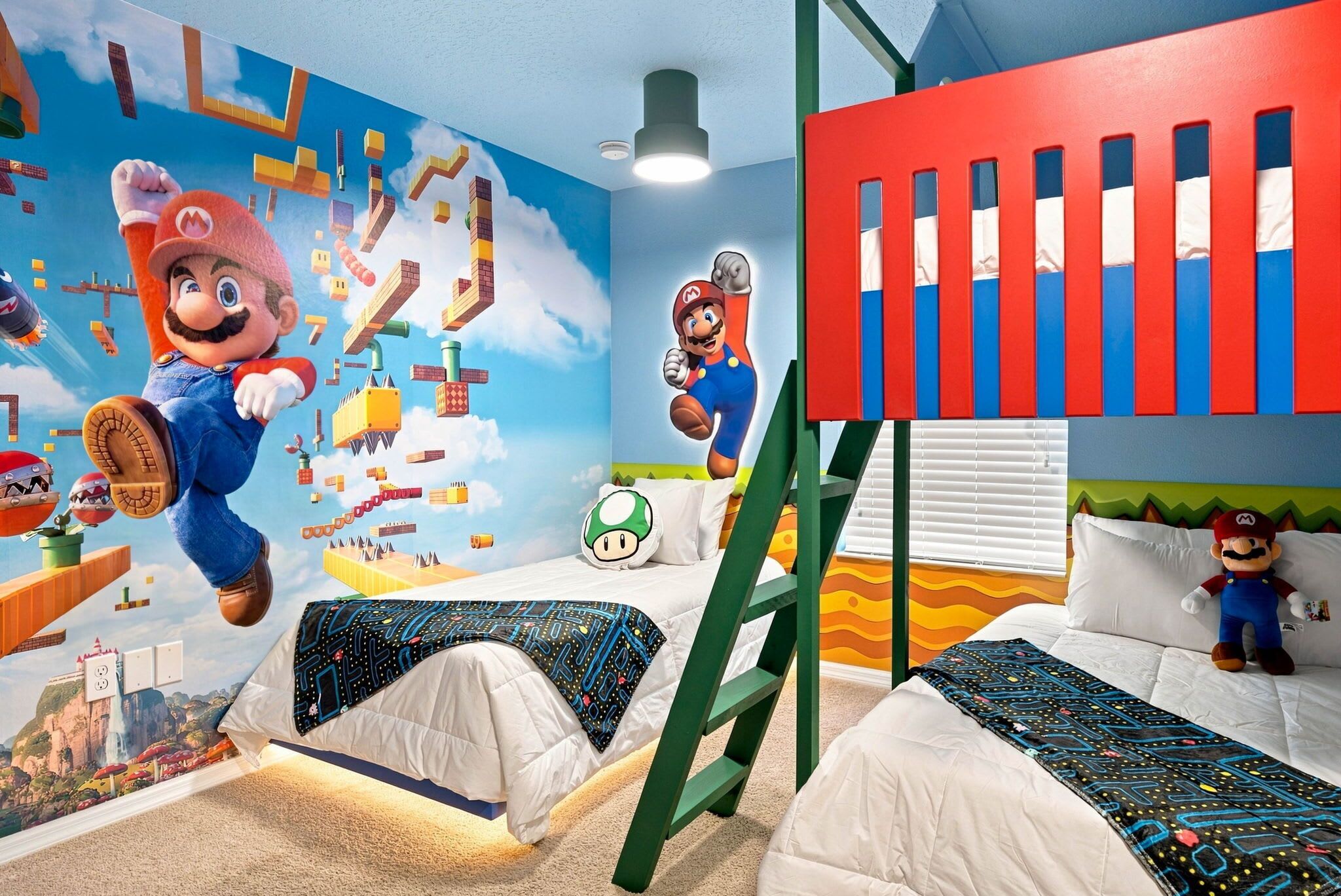 Et børneværelse med to senge, et vægmaleri af Mario, en stige og et vindue med persienner.