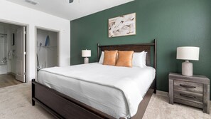 A bedroom with a bed, bedside tables, a lamp, and a painting on the wall. - Landing | Chic 2BD, Gym, Clubhouse (Port Charlotte)