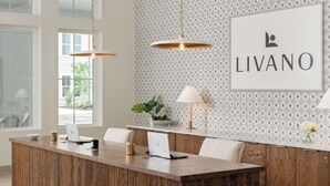 A modern kitchen with a wooden island, pendant lighting, and a wall-mounted sign. - Landing | Stylish 2BD, Gym, Clubhouse (Port Charlotte)