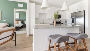A modern kitchen with white cabinets, a stainless steel refrigerator, and a granite countertop. - Landing | Incredible 2BD, Clubhouse, Pool (Port Charlotte)
