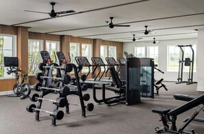 A modern gym with various exercise equipment, large windows, and ceiling fans. - Landing | Modern 2BD, Clubhouse, Gym (Port Charlotte)