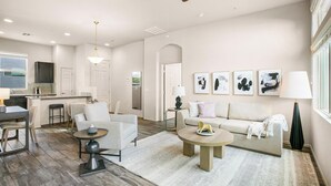 A modern living room with a sofa, chairs, a coffee table, and artwork on the wall. - Landing | Stylish 2BD, Pool, Clubhouse (Port Charlotte)
