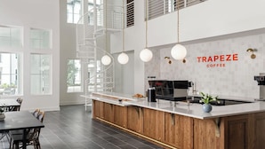 Una cocina moderna con una isla central, una cafetera y un cartel que dice 'TRAPEZE COFFEE'.