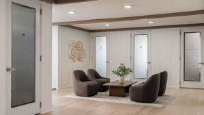 Un espacio de oficina moderno con piso de madera, una mesa central con sillas y un adorno en la pared.