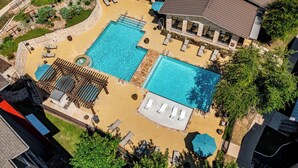 Ein Dachpool mit Liegestühlen, einem Whirlpool und einer überdachten Lounge.