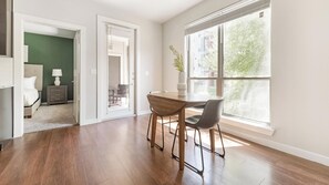 Ein modernes Interieur mit Essbereich, einem Bett und Blick ins Freie.