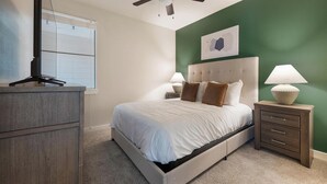 A bedroom with a bed, bedside tables, a dresser, a ceiling fan, and a window. - Landing | Modern 2BD, Pool, Gym (Austin)