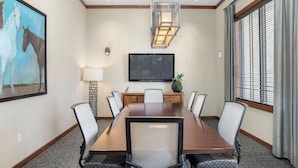 A conference room with a long table, chairs, a flat-screen TV, and a painting of horses. - Landing | Beautiful 2BD, Pool, Gym (Austin)