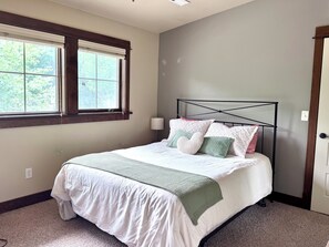 Ein Schlafzimmer mit Bett, Fenster und Tür.