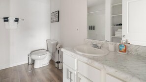 Une salle de bain moderne avec des toilettes, un lavabo et un miroir.
