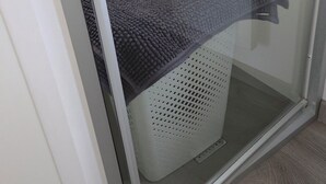 A room with a sliding glass door, a white basket, and a window. - The Mar Estang Oasis (Canet-en-Roussillon)