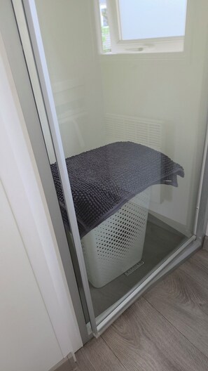Ein Zimmer mit einer Schiebeglastür, einem weißen Korb und einem Fenster.