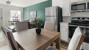 A modern kitchen with a built-in microwave, oven, and refrigerator. - Landing | Beautiful 2BD, Pool (Houston)