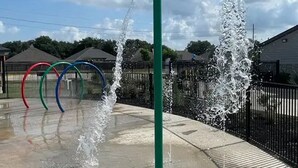 A water play area with multiple water jets and colorful rings. - Landing | Stylish 2BD, Pool (Houston)