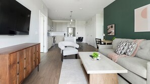 Uma sala de estar moderna com um sofá, uma mesa de centro e uma televisão.