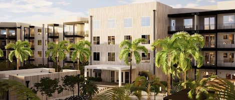 Un hôtel moderne à plusieurs étages, doté d’une cour intérieure agrémentée de palmiers et d’un espace salon abrité.
