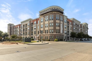 A multi-story building with a curved corner, large windows, and a flat roof. - Landing | Incredible 2BD, Rooftop Lounge (Fort Worth)