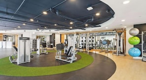Ein modernes Fitnessstudio mit verschiedenen Trainingsgeräten, darunter Kraftgeräte und Kurzhanteln.