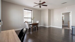 A spacious dining area with a wooden table and chairs, a ceiling fan, and a window with blinds. - Landing | Amazing 2BD, Gym, Courtyard (San Antonio)