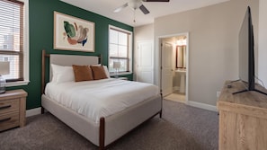 A bedroom with a bed, a nightstand, a dresser, a ceiling fan, and a television. - Landing | Amazing 2BD, Gym, Courtyard (San Antonio)