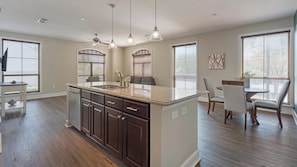 A modern kitchen with a central island, built-in appliances, and pendant lighting. - Landing | Spectacular 2BD, Courtyard, Gym (San Antonio)