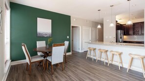 A modern kitchen with a central island, bar stools, and pendant lighting. - Landing | Spectacular 2BD, Gym, Courtyard (San Antonio)