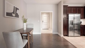 Une cuisine moderne avec des meubles de couleur bois foncé et un réfrigérateur en acier inoxydable.