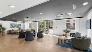 Eine moderne Lobby mit Sitzgelegenheit, einem Couchtisch und einer Zimmerpflanze.